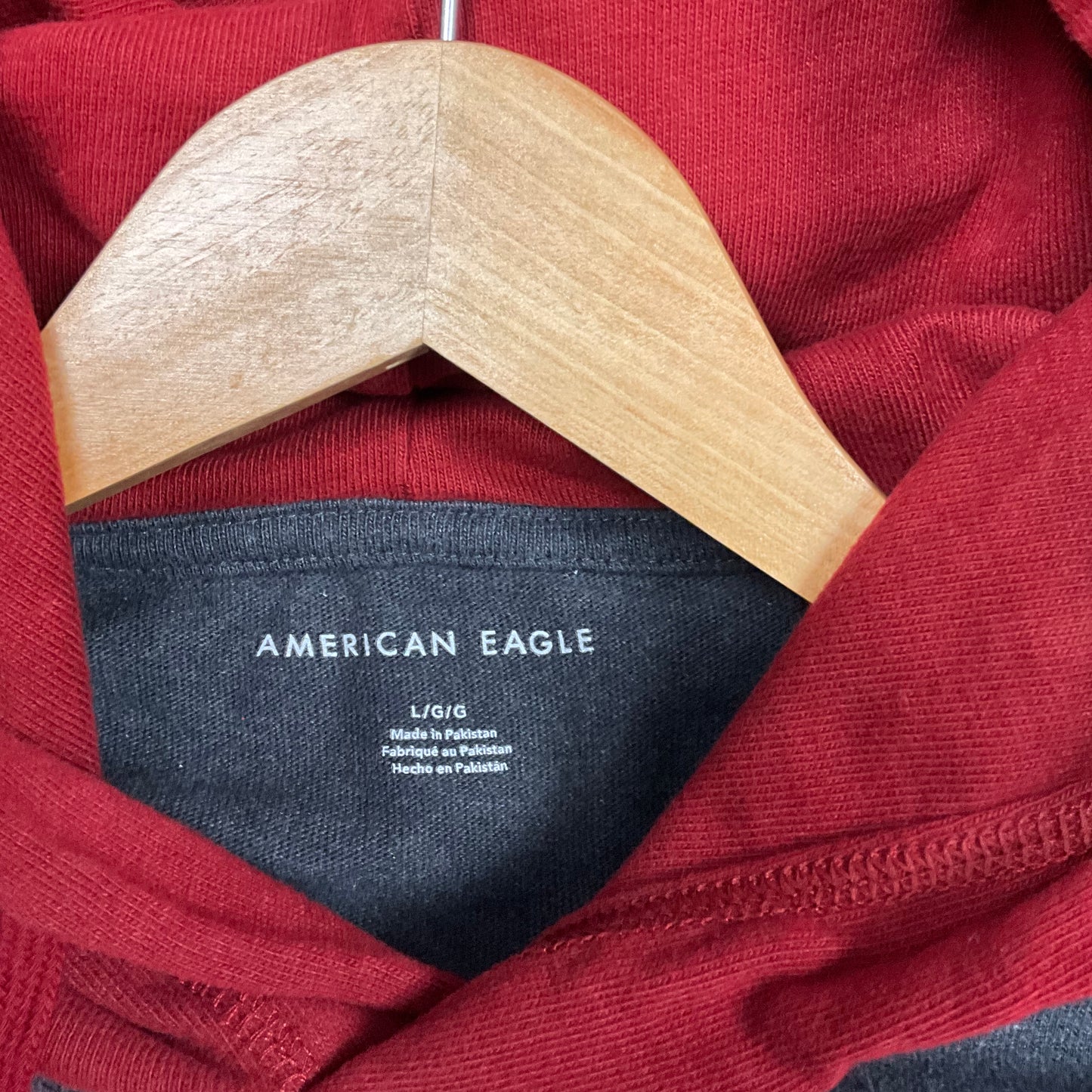 Sudadera con capucha y mangas a rayas color burdeos de American Eagle.